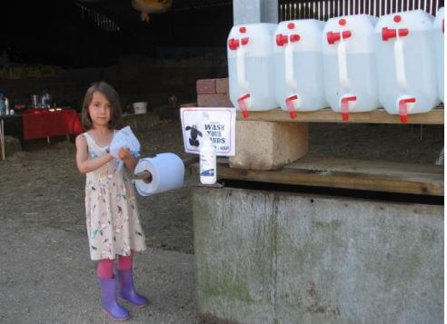 Photo of girl using hand wash facilities at farm